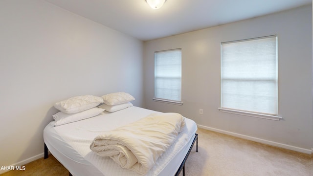 bedroom featuring baseboards and light colored carpet