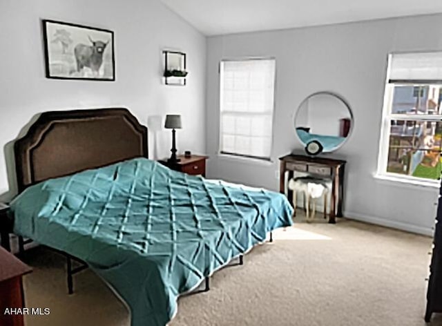 carpeted bedroom featuring lofted ceiling and baseboards