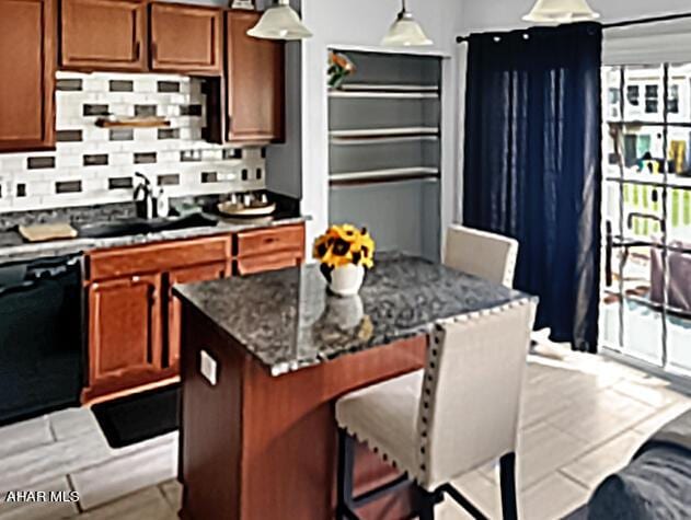 kitchen with tasteful backsplash, hanging light fixtures, a sink, a kitchen island, and dishwasher