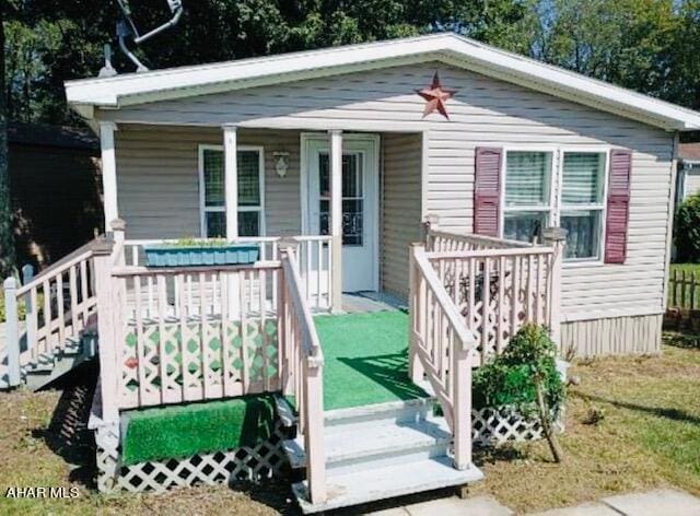 bungalow-style home featuring covered porch and a front lawn