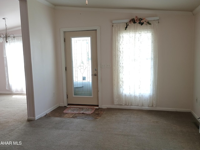 foyer entrance with carpet flooring, a chandelier, and ornamental molding