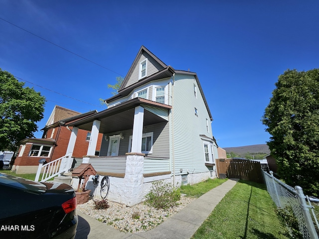 view of front of house featuring fence and covered porch