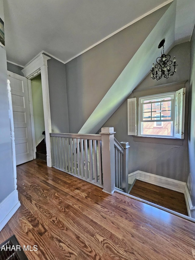 additional living space with baseboards, lofted ceiling, and wood finished floors