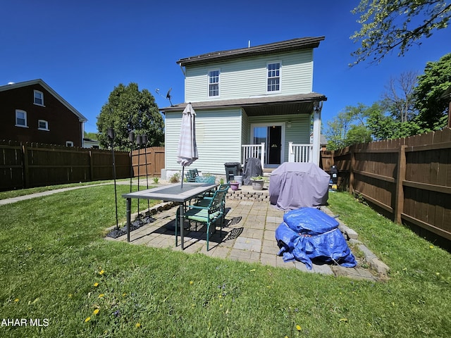 rear view of property with a patio, a fenced backyard, and a yard