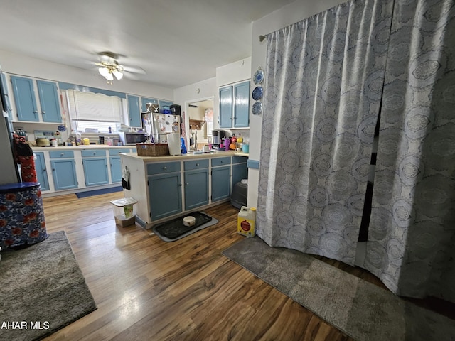 2802 Elm St, Altoona, PA 16601 - kitchen with blue cabinetry, wood finished floors, freestanding refrigerator, ceiling fan, and light countertops
