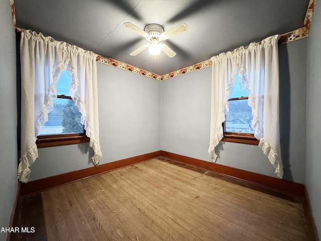 unfurnished room with ceiling fan, baseboards, and hardwood / wood-style flooring