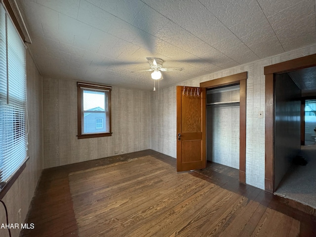 unfurnished bedroom featuring elevator, ceiling fan, and dark hardwood / wood-style flooring