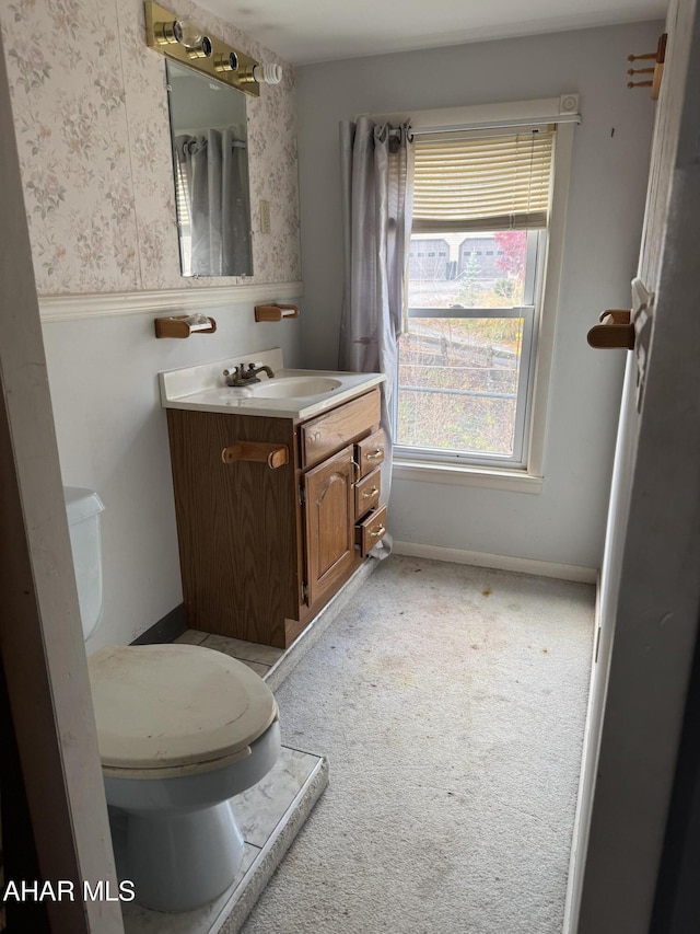 bathroom featuring vanity, toilet, and baseboards