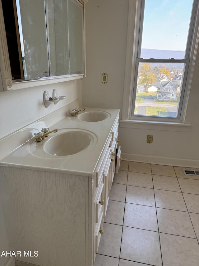 bathroom featuring double vanity, visible vents, a sink, and tile patterned floors