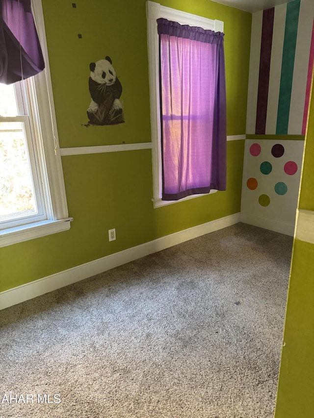 carpeted empty room with baseboards