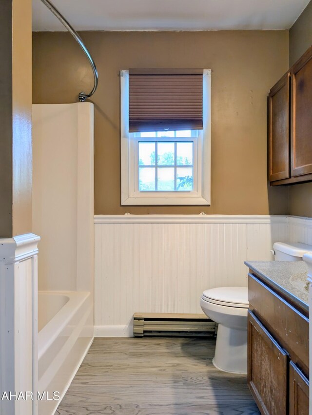 151 Rio Grande Rd, Clearville, PA 15535 - full bath featuring a baseboard radiator, a wainscoted wall, toilet, wood finished floors, and vanity