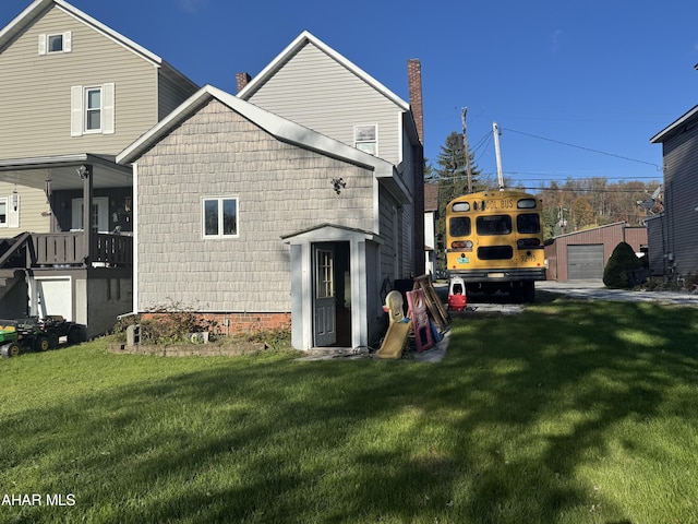 rear view of property with a yard and an outdoor structure