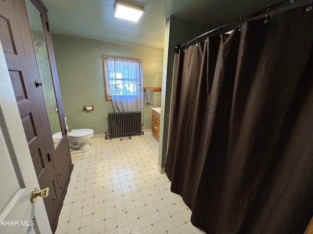 bathroom with radiator heating unit, vanity, and toilet