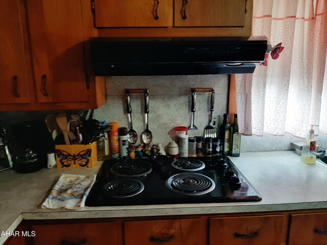 304 Forest St, Gallitzin, PA 16641 - kitchen featuring range hood, black cooktop, light countertops, and brown cabinetry