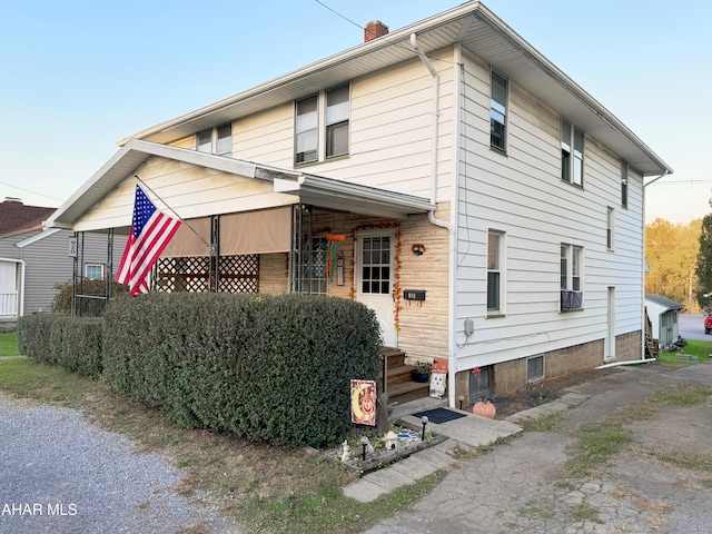 view of front of house featuring entry steps and a chimney