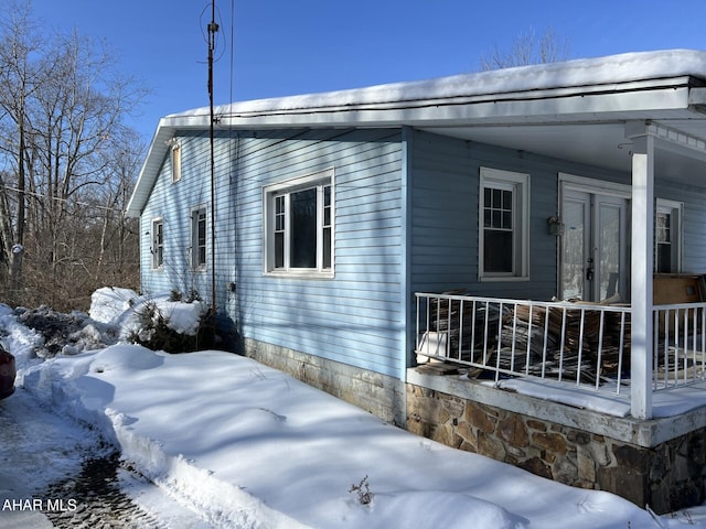 view of snow covered exterior with covered porch