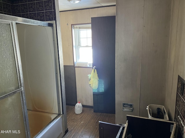 bathroom featuring hardwood / wood-style flooring and enclosed tub / shower combo