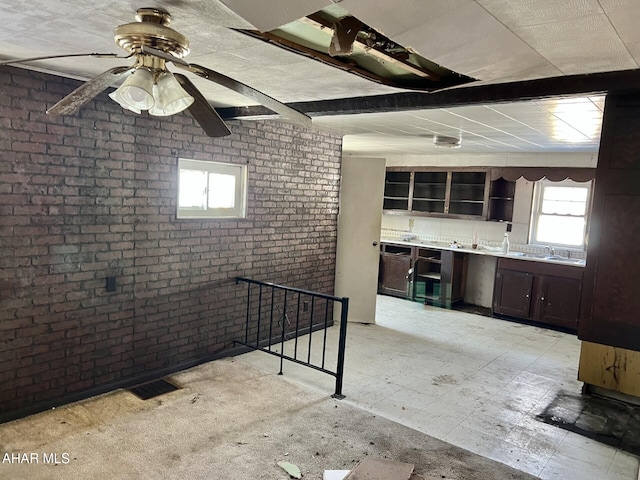 interior space with brick wall and ceiling fan