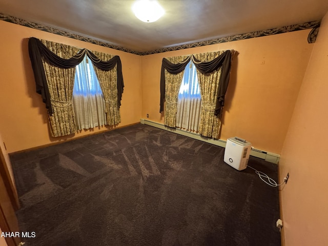 carpeted spare room featuring a baseboard radiator and plenty of natural light