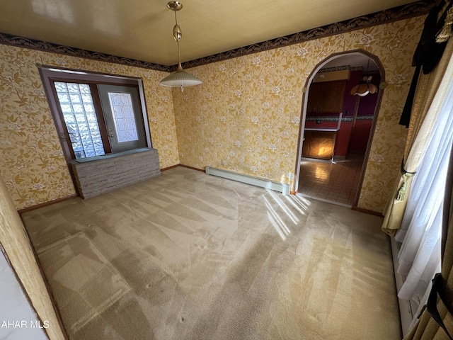 spare room with carpet flooring and a baseboard heating unit