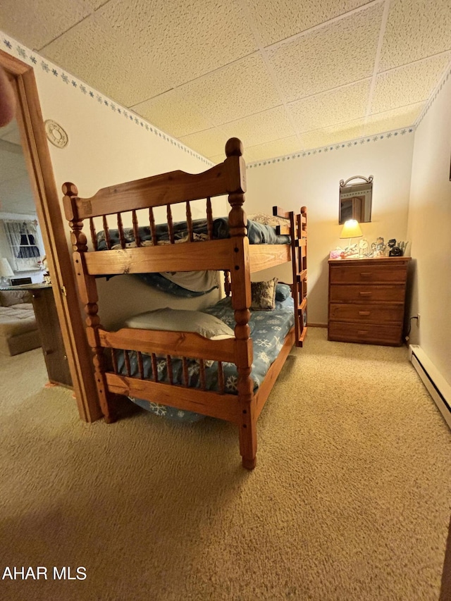 carpeted bedroom featuring a drop ceiling