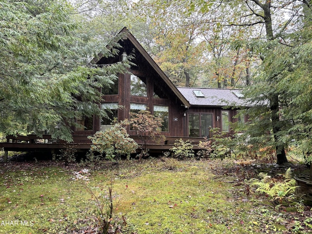 view of side of property with a yard and a deck