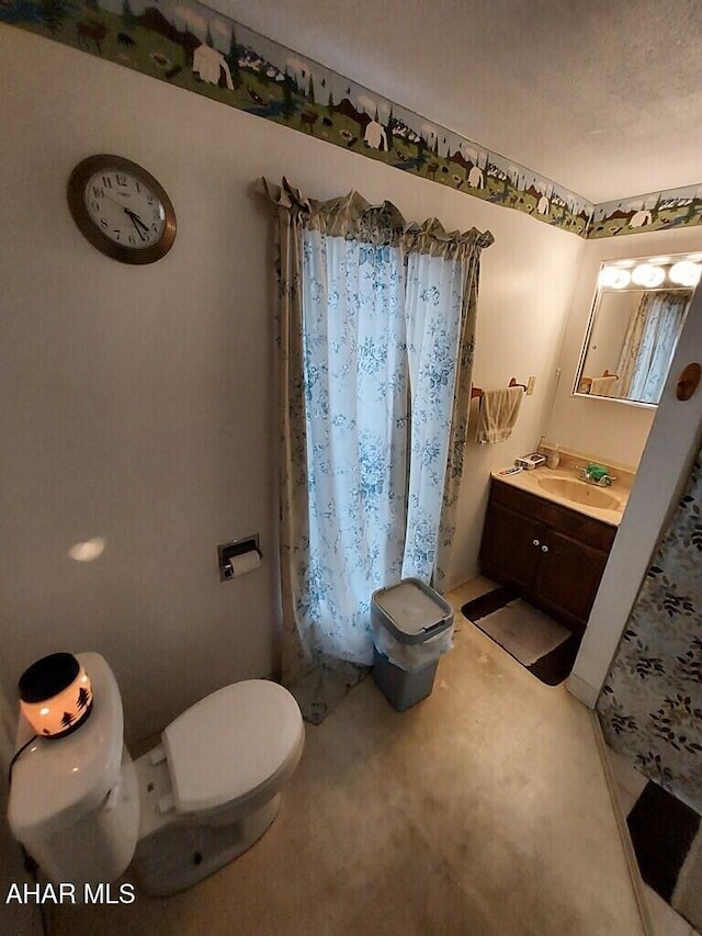 bathroom featuring a textured ceiling, toilet, and vanity