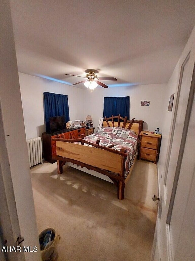 carpeted bedroom featuring ceiling fan and radiator heating unit