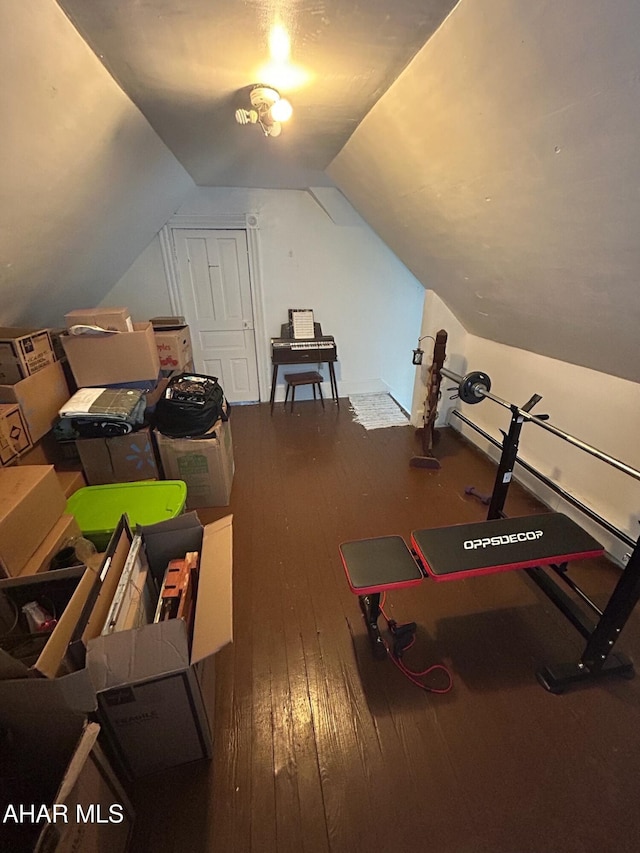 exercise room with hardwood / wood-style flooring and lofted ceiling