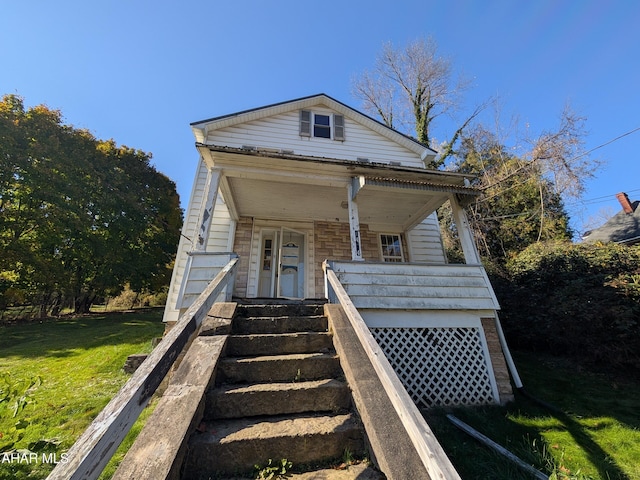 view of front of house with a porch and a front lawn