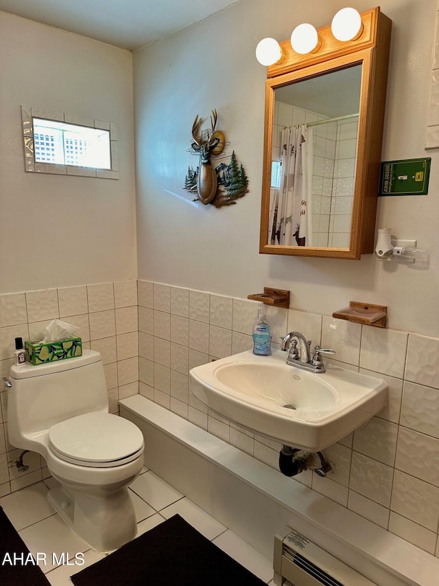 bathroom featuring a baseboard heating unit, sink, tile walls, tile patterned flooring, and toilet