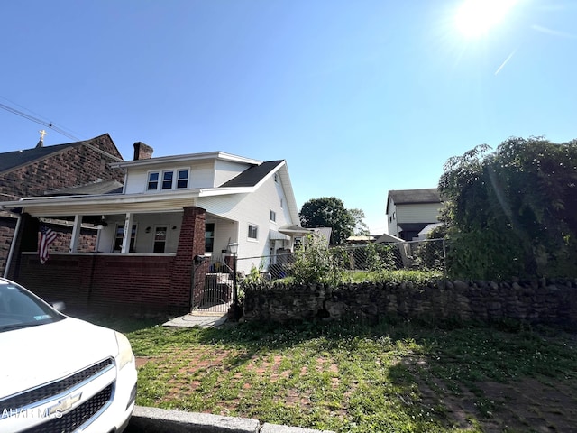 1211 20th St, Altoona, PA 16601 - view of side of property with a gate, a chimney, brick siding, and a porch