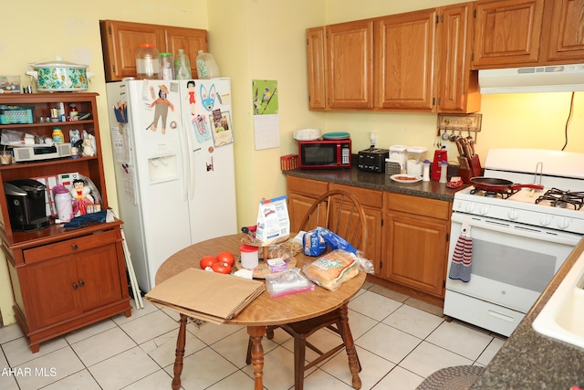 1211 20th St, Altoona, PA 16601 - kitchen featuring under cabinet range hood, white appliances, light tile patterned flooring, dark countertops, and brown cabinets