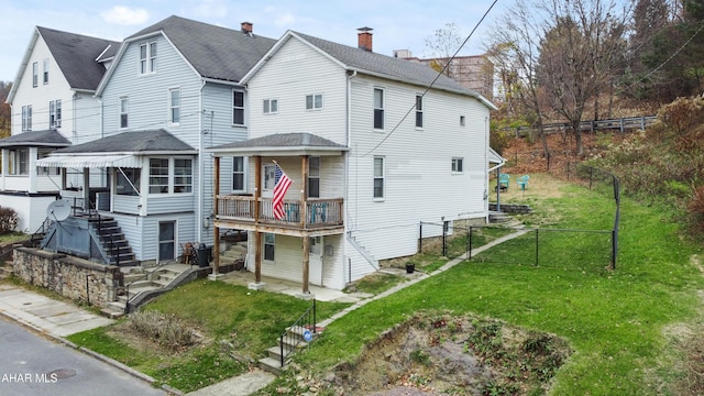 rear view of house featuring a yard and a wooden deck