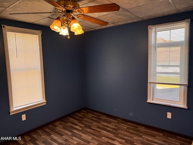 unfurnished room featuring plenty of natural light, ceiling fan, and dark hardwood / wood-style flooring