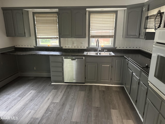 kitchen featuring dark hardwood / wood-style flooring, stainless steel appliances, gray cabinets, and sink