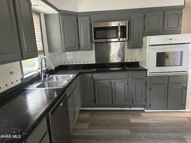 kitchen featuring gray cabinetry, sink, appliances with stainless steel finishes, and dark wood-type flooring