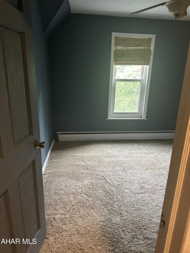 carpeted empty room with ceiling fan and a baseboard radiator