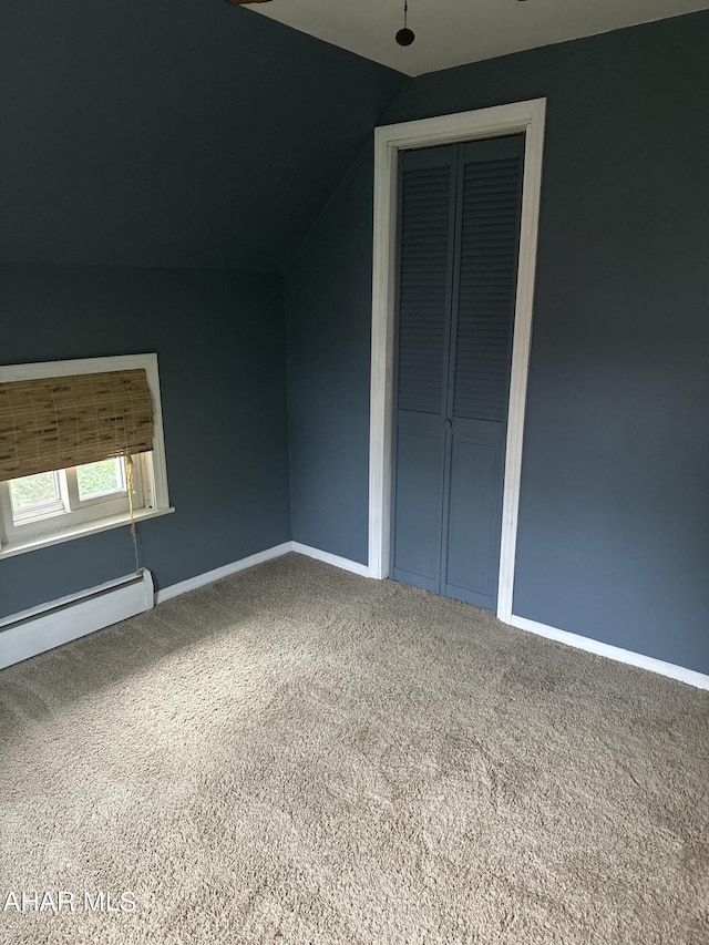 additional living space with carpet floors, baseboard heating, and lofted ceiling