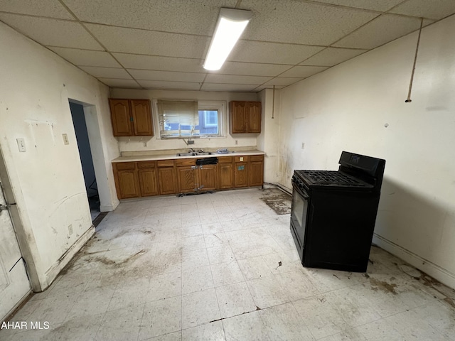 kitchen featuring gas stove, a drop ceiling, and sink