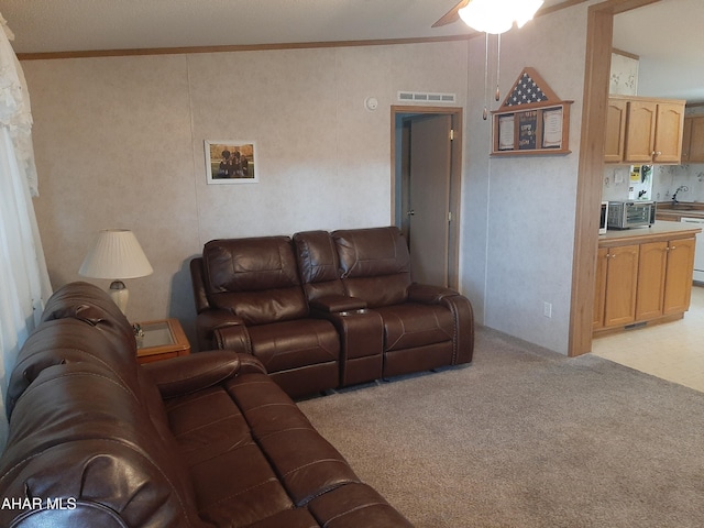 carpeted living room featuring ceiling fan, ornamental molding, and vaulted ceiling