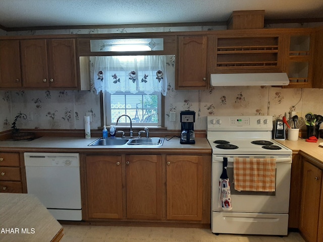 kitchen featuring a textured ceiling, white appliances, and sink