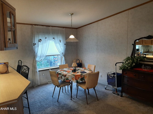 carpeted dining room with crown molding