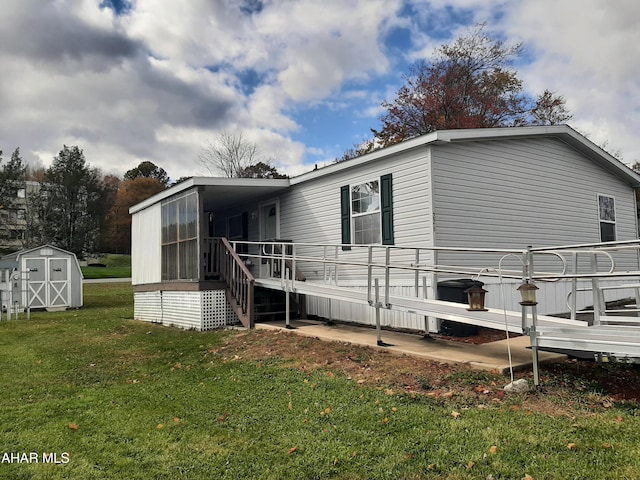 rear view of house with a lawn, a sunroom, a storage shed, and a wooden deck