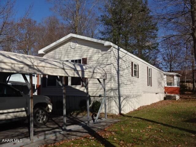 view of side of home with a yard and a carport