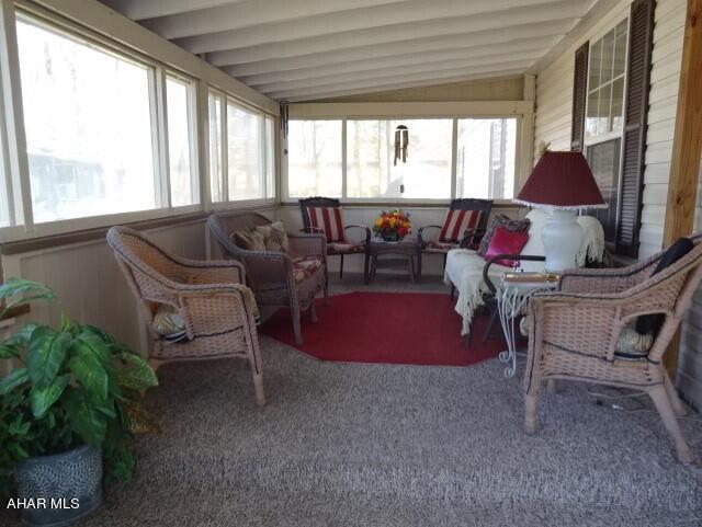 sunroom featuring lofted ceiling with beams