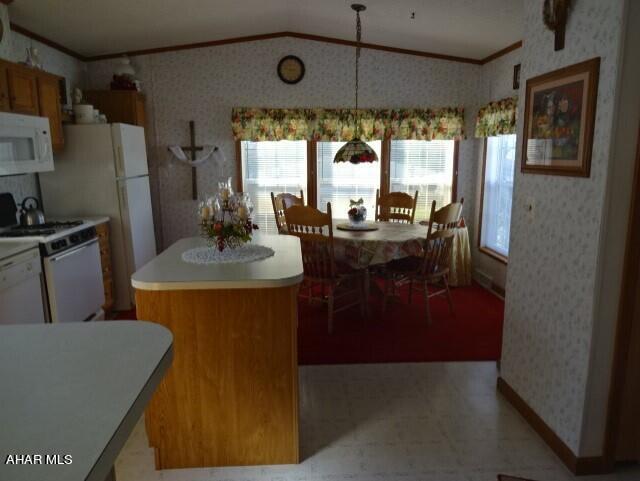 kitchen featuring white appliances, vaulted ceiling, crown molding, a kitchen island, and hanging light fixtures