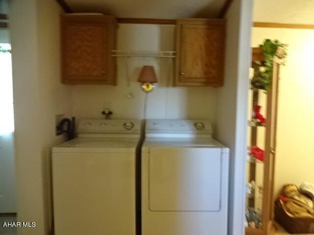 clothes washing area featuring cabinets and washer and dryer