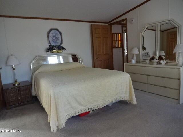 carpeted bedroom with vaulted ceiling and crown molding