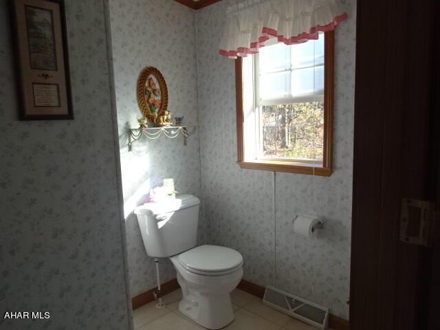 bathroom with toilet and tile patterned floors